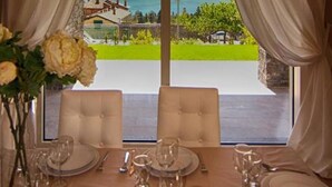 Une table à manger dressée pour quatre personnes, avec vue sur une montagne et un lac.