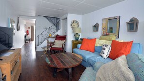 A living room with a blue sofa, wooden coffee table, and a TV stand.