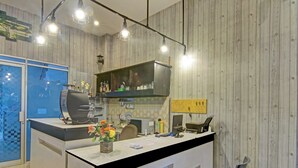 Een receptiebalie met een computer, een vaas met bloemen en een wandlamp.