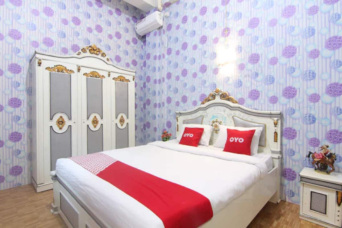 A bedroom with a bed, a wardrobe, and a nightstand.