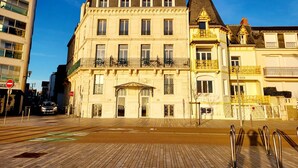 Un bâtiment historique doté d’une entrée centrale, de nombreuses fenêtres et de balcons.
