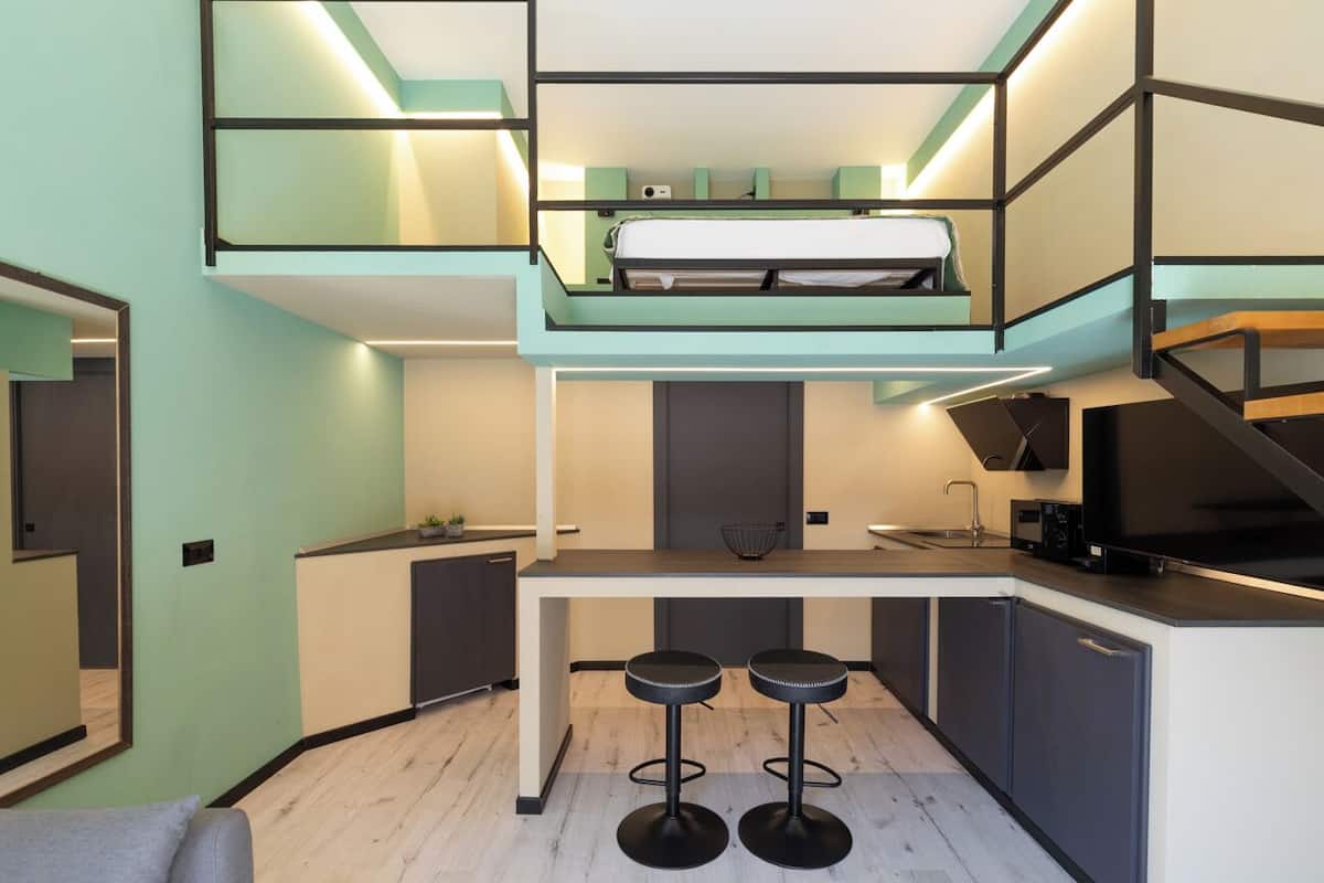 Eine kompakte, moderne Wohnung mit Schlafgalerie, einer Küchenzeile und einem Essbereich.