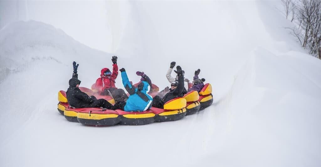 A group of people in a snow tube ride.