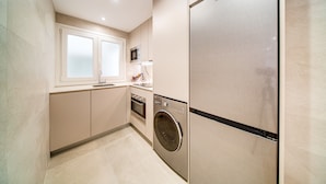 A modern kitchen with a stainless steel refrigerator, built-in oven, microwave, and washing machine. - Apartamento muy Coqueto a 5 Min, Pabellon Principe Felipe (Zaragoza)