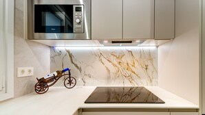 A modern kitchen with a built-in microwave, a wine cooler, and a sleek countertop. - Apartamento muy Coqueto a 5 Min, Pabellon Principe Felipe (Zaragoza)