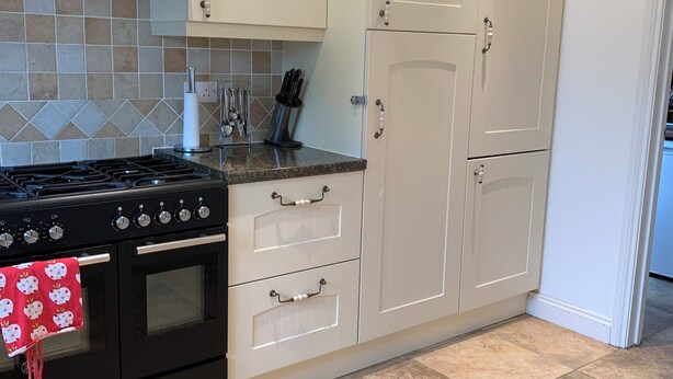 A kitchen with a stove, oven, and white cabinets. - Coventry Charm - Spacious 3 Bedroom House (Coventry)