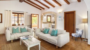 Un salon chaleureux avec deux canapés blancs, une table basse et un plafond en bois.