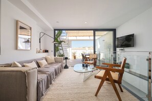 Ein modernes Wohnzimmer mit einer Couch, einem Couchtisch und einem Fernseher.