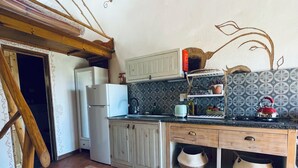 A kitchen with a refrigerator, stove, and wooden cabinets. - Destination for Couple, Surfers, Hikers, and Nature Lovers! (Carrapateira)