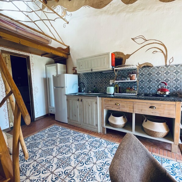 A kitchen with a refrigerator, stove, and wooden cabinets.