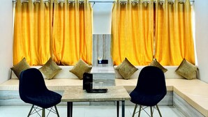 Un comedor moderno con una mesa de mármol, dos sillas y un banco con cojines.