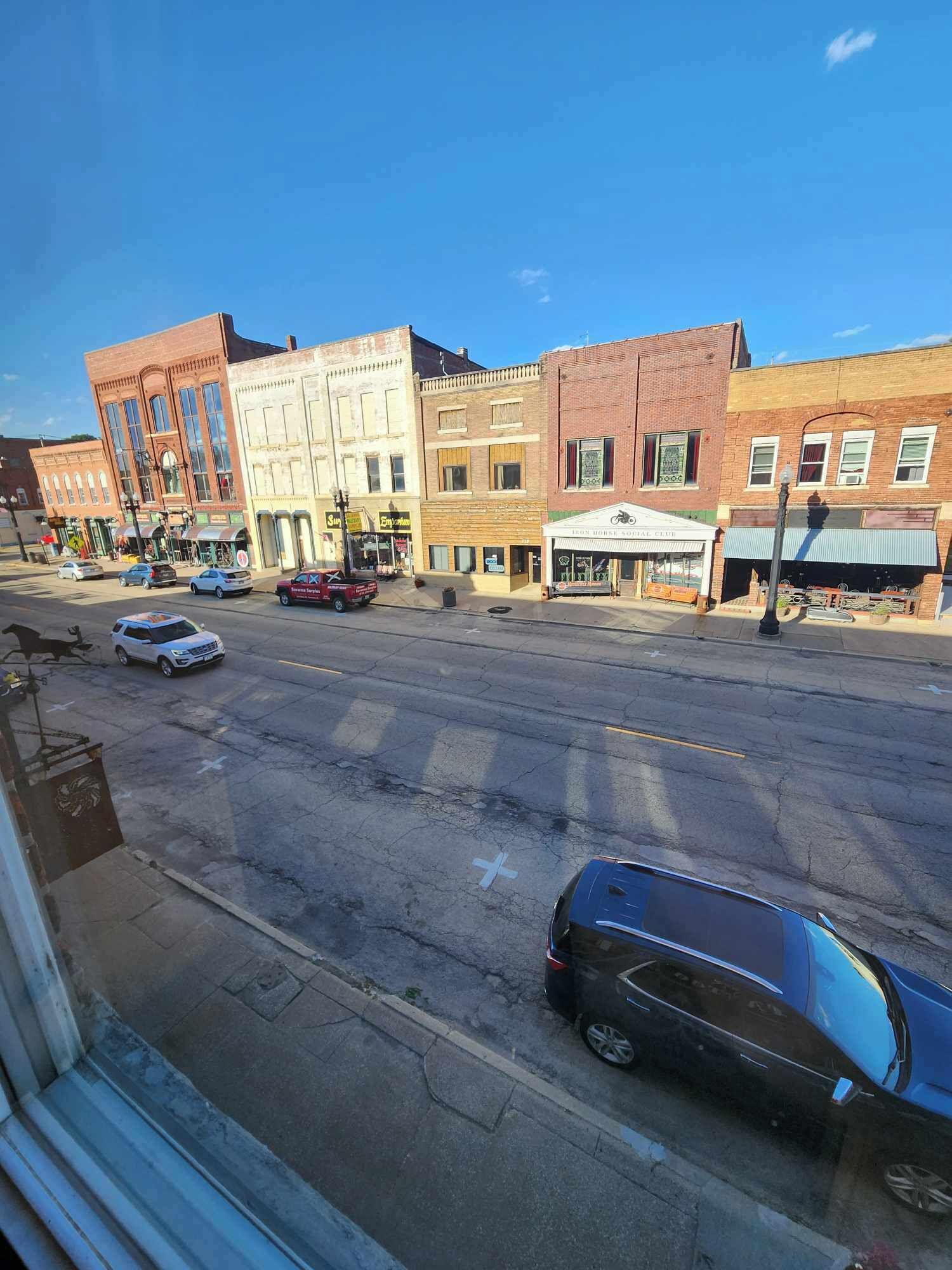Une vue de rue avec différents bâtiments, dont un restaurant et un magasin.