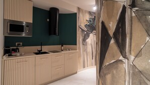 A modern kitchen with a built-in microwave, a coffee maker, and a wine bottle on the counter. - Elegant city center apartment close to all city attractions (Cagliari)