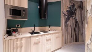 A modern kitchen with a microwave, sink, and a decorative wall. - Elegant city center apartment close to all city attractions (Cagliari)
