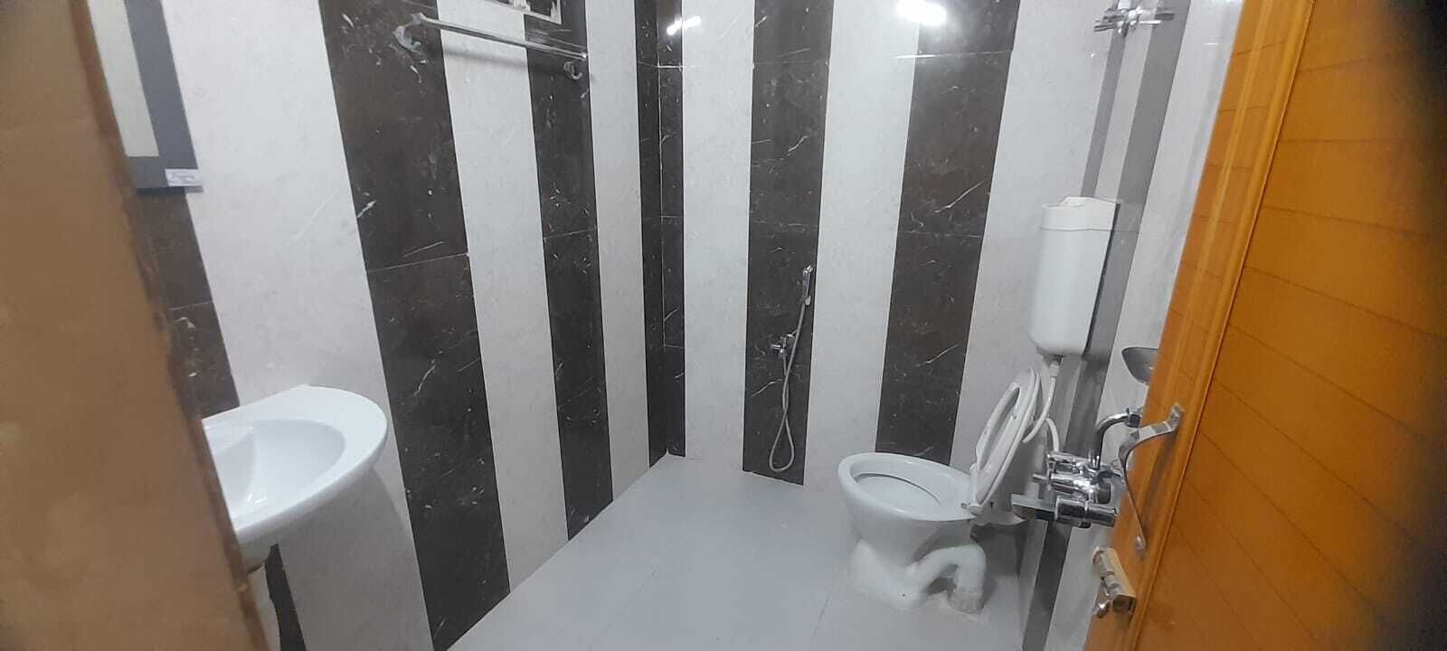 Un baño pequeño con inodoro, lavamanos y ducha.