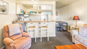 A compact living space with a kitchenette, a dining area, and seating arrangements. - So Very Nice in Ocean Shores (Ocean Shores)