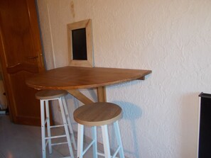 Enjoy meals at a cozy dining table with two stools.