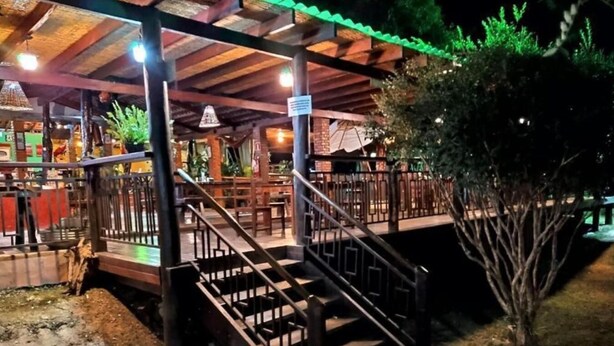 A covered outdoor area with wooden stairs leading to a seating area. - Pousada Chalé Cantinho de Minas  (São João Batista do Glória)