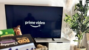 Ein Fernseher mit dem Prime Video-Logo, eine Snackauswahl und ein Blumentopf.