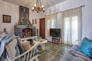 Un salon avec une cheminée, un téléviseur et un coin salon.