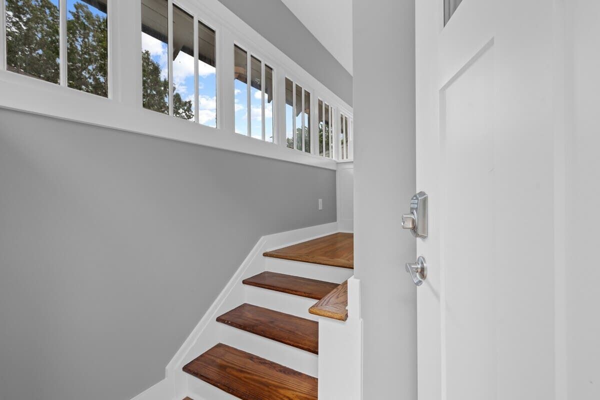 A staircase with wooden steps and a white door.