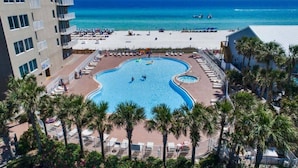Ein Resort mit einem zentralen Schwimmbad, einer Strandanlage und Blick auf den Ozean.