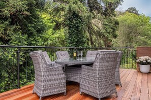 An outdoor patio with wicker furniture, a glass table, and wine glasses. - East Hampton, Sandsend Retreats at Saltmoore - East Hampton (Whitby)