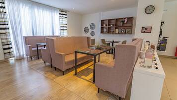 A modern living room with a sofa set, a coffee table, and a dining area.