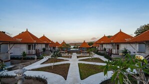 A row of white buildings with orange roofs and a central pathway. - Island Retreat Cottage (Lembongan Island)