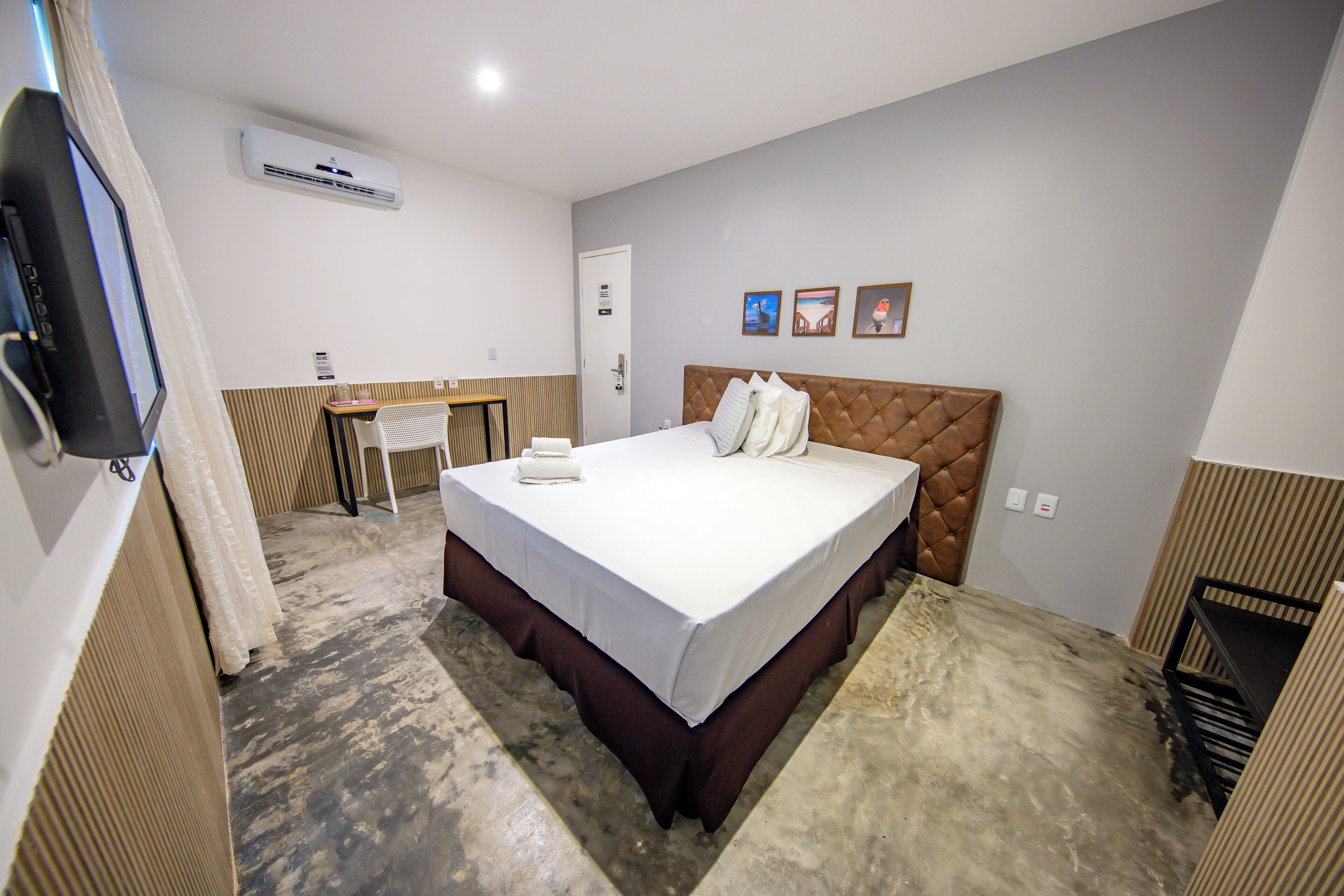 Una habitación de hotel con cama, escritorio y televisión.