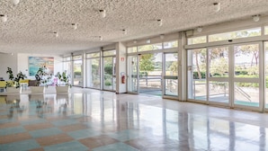 A spacious lobby with a high ceiling, large windows, and a checkered floor. - Italian Experience- Suite MareConero (Porto Recanati)