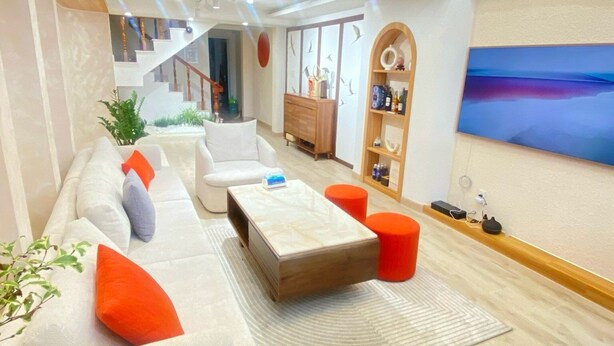 A modern living room with a sofa set, a coffee table, and a staircase leading to an upper level. - CC Xanh Xanh (Xuan Huong - Da Lat)