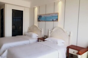 A hotel room with two beds, a nightstand, and a painting on the wall. - Peninsula Holiday Hotel (Nan'ao County)