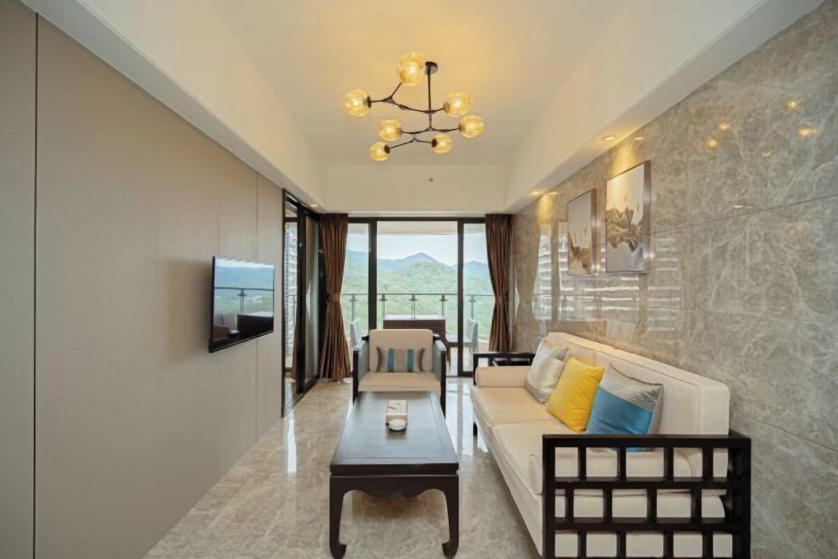 A modern living room with a sofa, a coffee table, and a TV mounted on the wall.