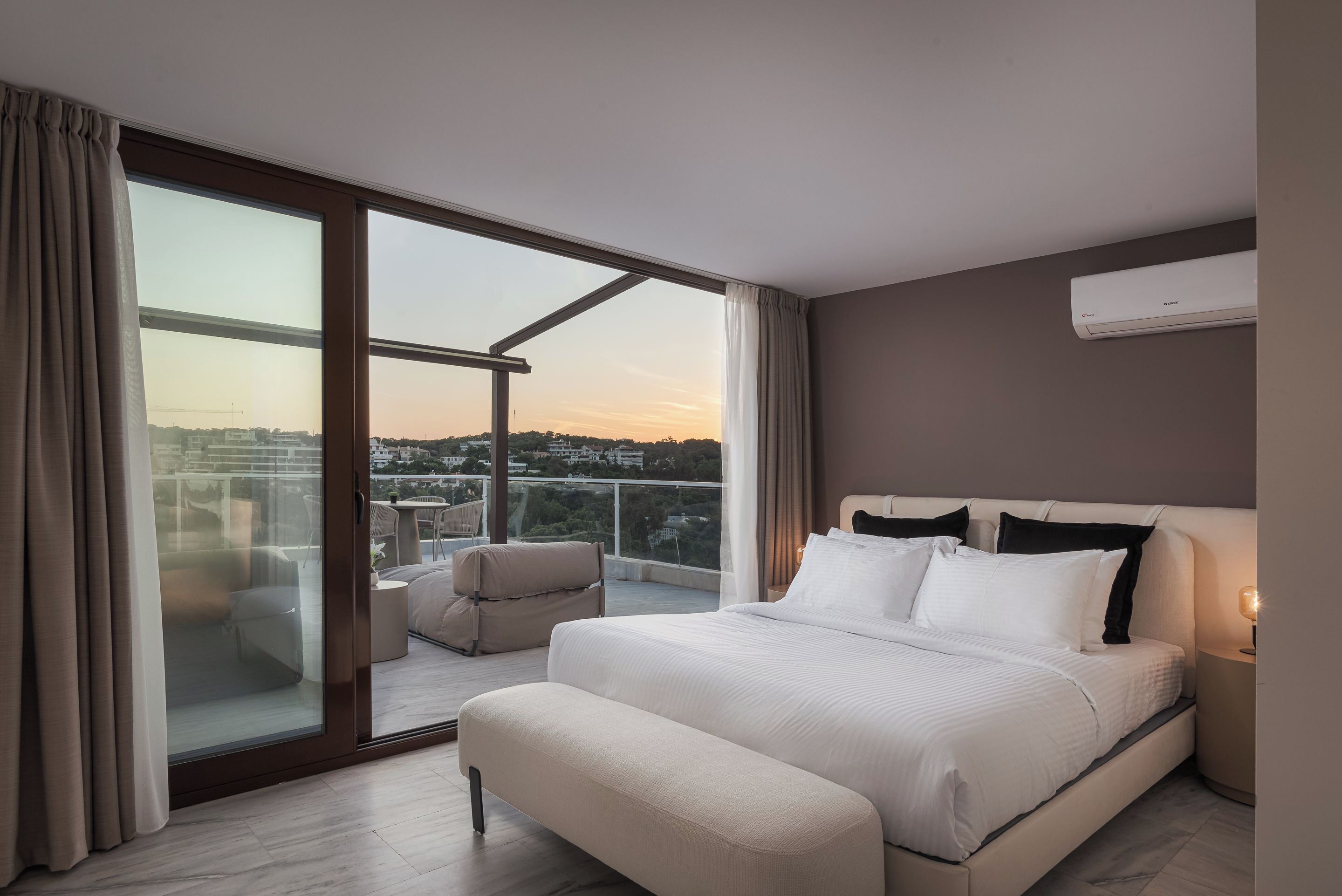 Une chambre moderne dotée d’un grand lit, d’un balcon avec vue et d’un climatiseur fixé au plafond.