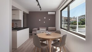 Eine moderne Wohnung mit Küche, Essbereich und großem Fenster mit Blick auf die Stadt.