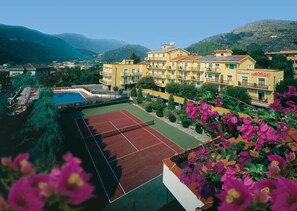 Un hôtel doté d’un court de tennis, d’une piscine et offrant une vue sur les montagnes.