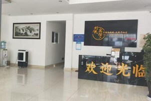 A reception area with a reception desk, a framed artwork on the wall, and a sign with text.