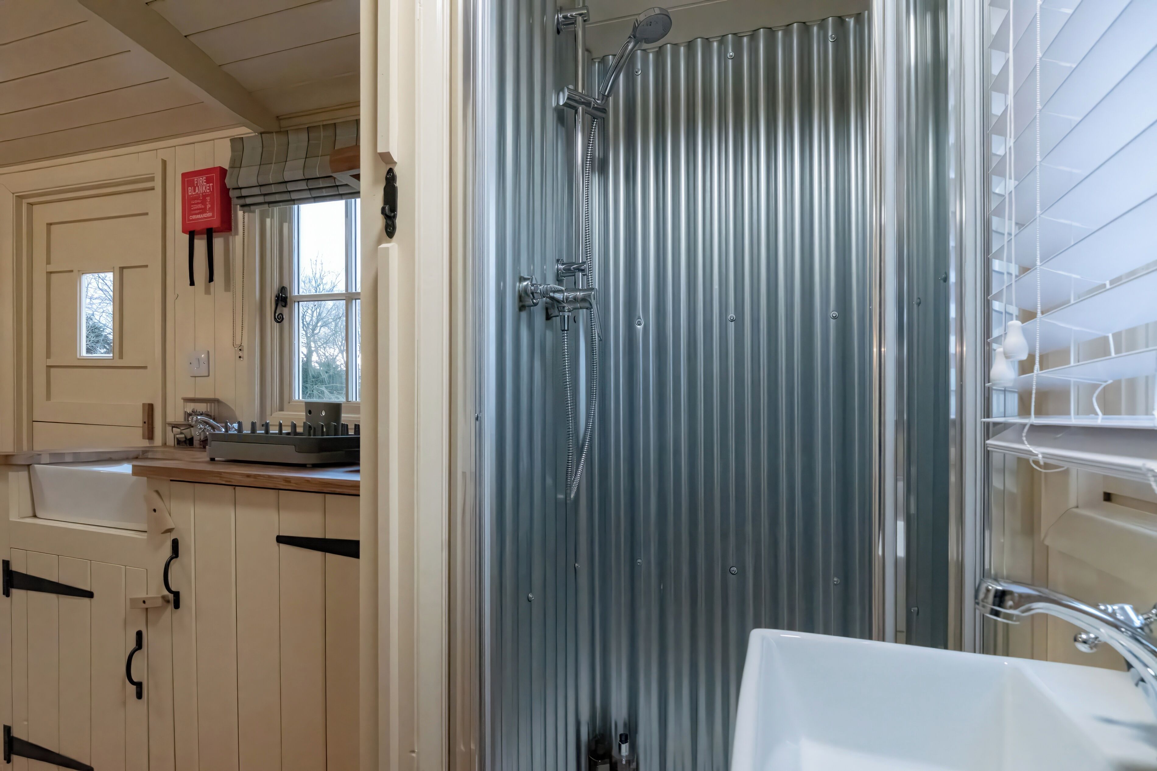 A bathroom with a shower, sink, and cabinets.