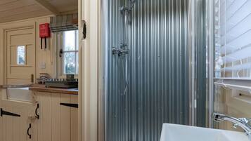 A bathroom with a shower, sink, and cabinets.