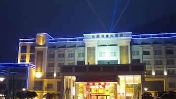 A hotel with a prominent entrance, multiple floors, and illuminated signage.