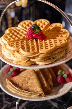 A stack of waffles with strawberries on top, arranged on a tiered serving dish. - Ginette à la Folie (Paris)