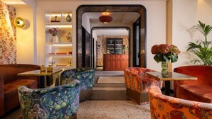 A modern living room with patterned sofas, a coffee table, and a bookshelf. - Ginette à la Folie (Paris)