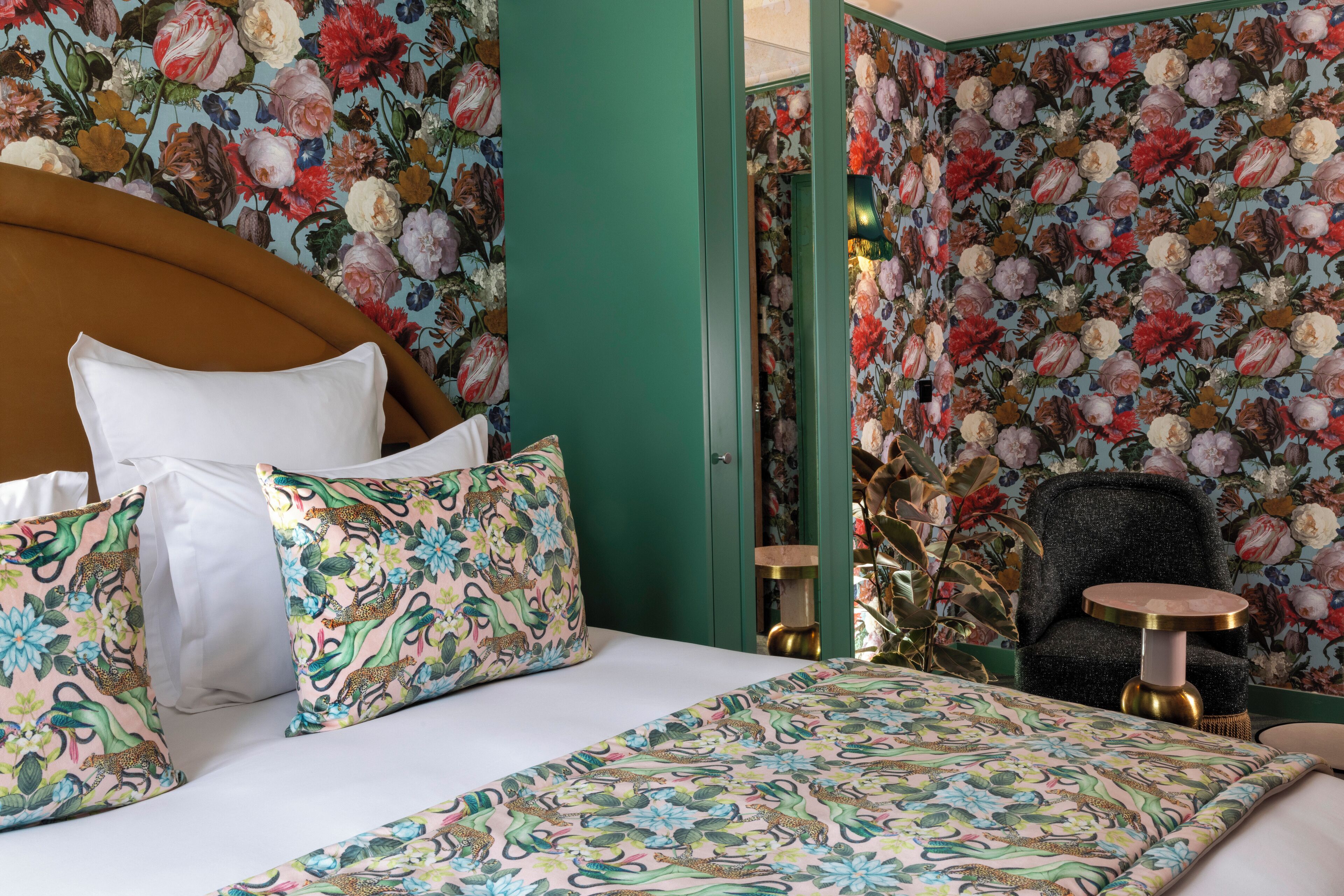 Ein Schlafzimmer mit blumigem Wandpapier, einem runden Tisch und einem Stuhl.