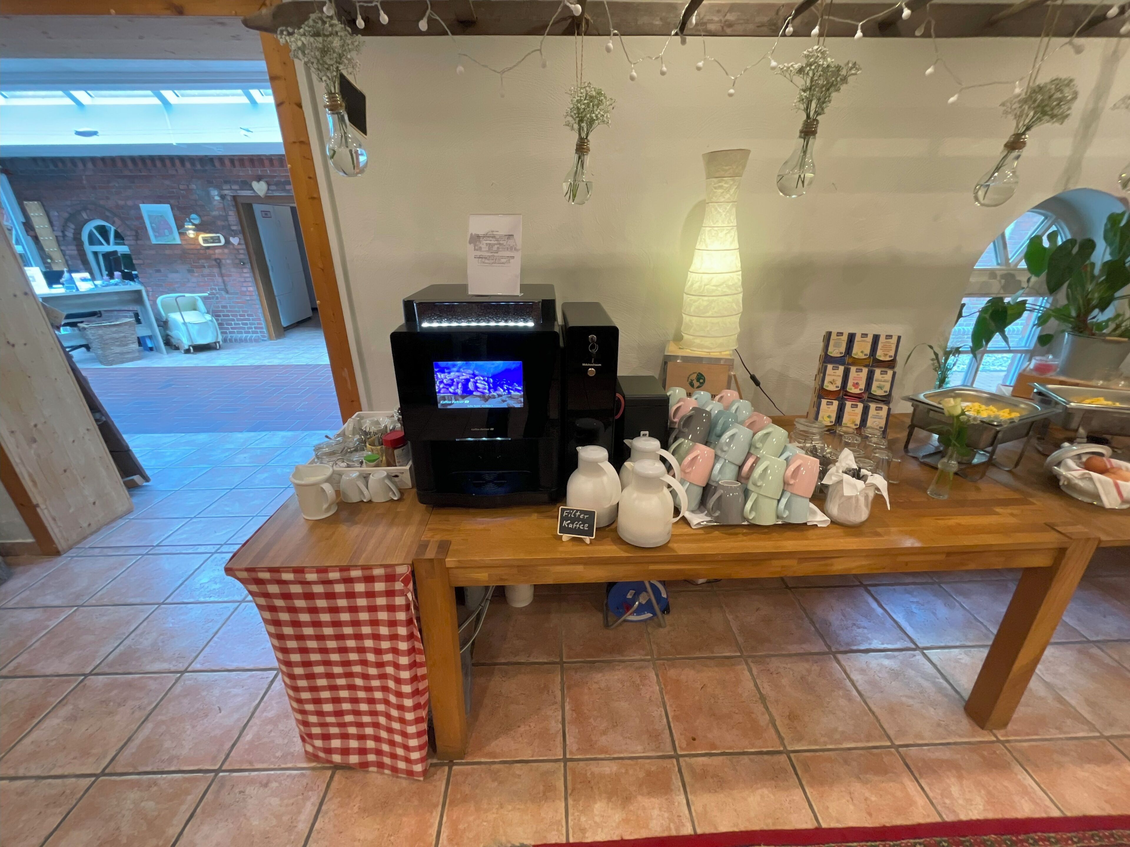 Un espace dédié au café, équipé d’une machine à café, de tasses et d’un panneau indiquant « Café filtre ».