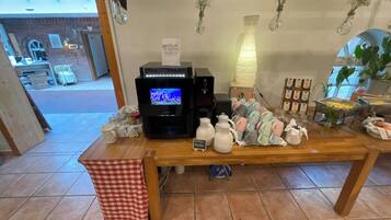 Un espace dédié au café, équipé d’une machine à café, de tasses et d’un panneau indiquant « Café filtre ».