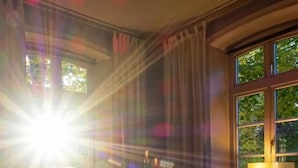 Ein Zimmer mit einem großen Fenster, einem Tisch und Stühlen.