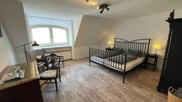 A bedroom with a bed, bedside tables, a desk, and a chair.