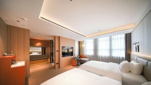 Una habitación de hotel moderna con una cama grande, un escritorio, un televisor y un baño.