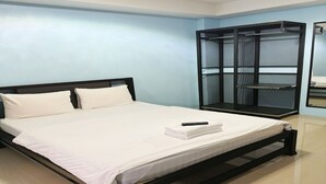 A neatly made bed with white linens and a remote control on top. - OYO 75506 Ratchapruek Apartment Suphanburi  (Suphan Buri)